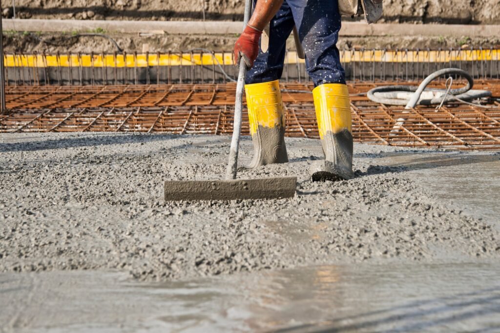 bricklayer who level the freshly poured concrete to lay the foundations of a building