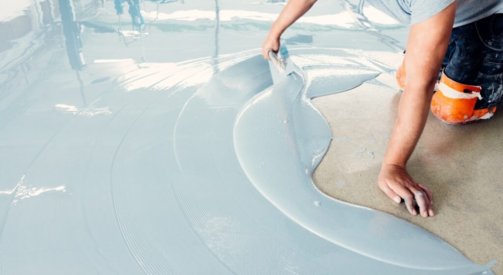 Zemin üzerine kendiliğinden seviyelenen beton serpen inşaat işçisi