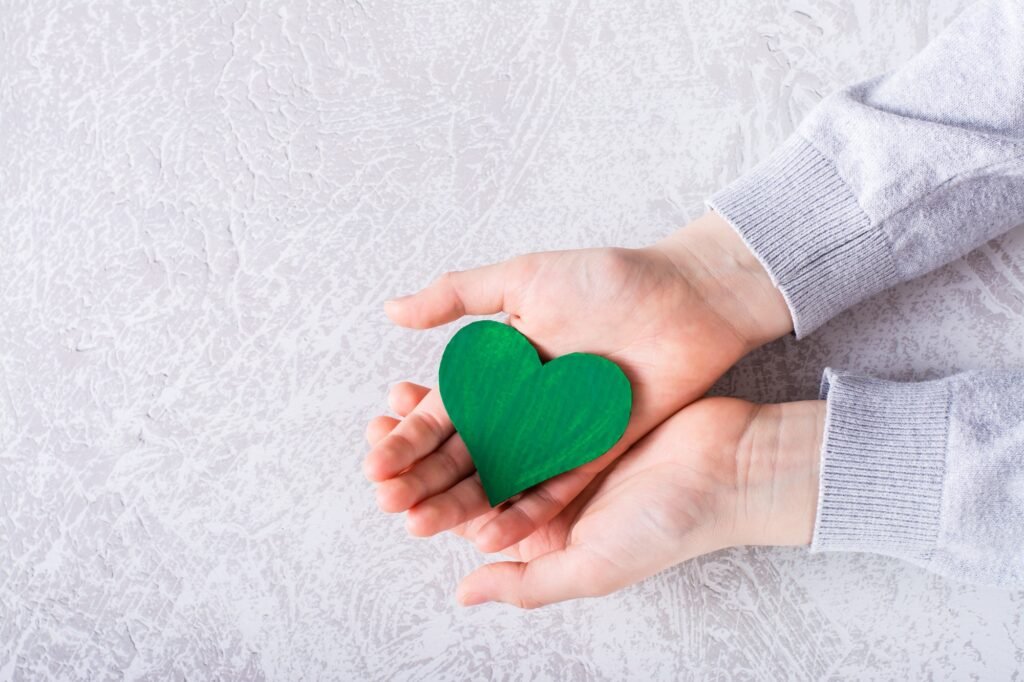 ESG environmental social management policy. Green heart in the palms.