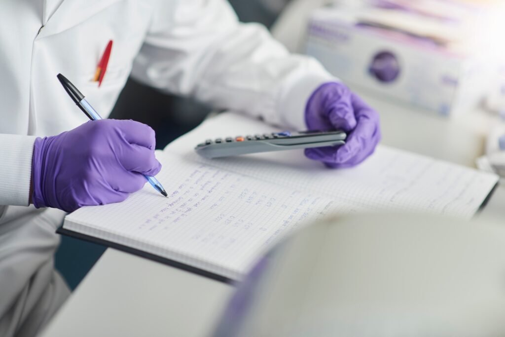 Hesap makinesi kullanan bilim insanı, deftere yazıyor